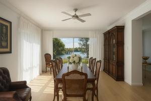 a dining room with a table and a ceiling fan at Creekside Manor - Spacious | Nature & Serenity - Holiday Home in Gold Coast