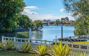 a view of a river with a white fence at Creekside Manor - Spacious | Nature & Serenity - Holiday Home in Gold Coast