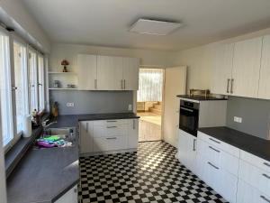 a kitchen with white cabinets and a black and white checkered floor at Haus Anna in Alpirsbach