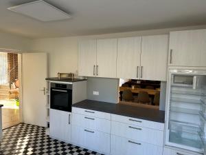 a kitchen with white cabinets and black counter tops at Haus Anna in Alpirsbach