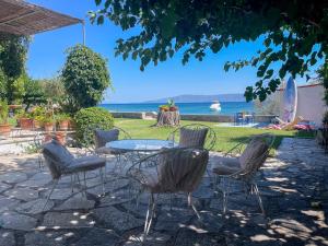a patio with chairs and a table with a view of the ocean at Beachfront Family Villa in Eretria