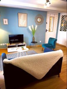 a living room with a couch and a tv at L'atelier du Charme Dole Centre in Dole +19 photos