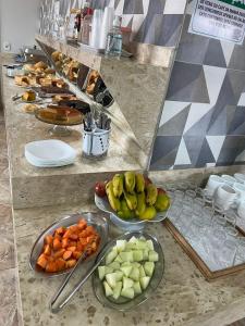 a buffet with bowls of fruit and vegetables on a counter at Hotel Porto Seguro in Querencia