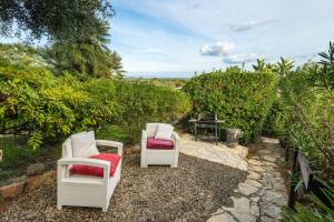 2 chaises et une table dans la cour dans l'établissement Villa Amaranta - Is Molas, à Is Molas 