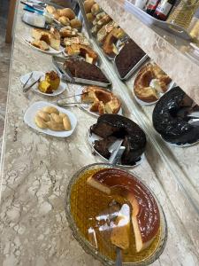 a table with a bunch of different types of pastries at Hotel Porto Seguro in Querencia +5 photos