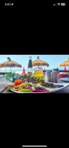 Ein Teller mit Gemüse auf einem Tisch mit Sonnenschirmen in der Unterkunft Nirvana Beach Cottages in Canacona + 16 Fotos