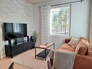 un salon avec un canapé et une télévision à écran plat dans l'établissement Särkänhelmi, à Kalajoki