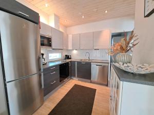 a kitchen with a stainless steel refrigerator and cabinets at Särkänhelmi in Kalajoki