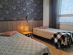 une chambre d'hôtel avec deux lits et une fenêtre dans l'établissement Särkänhelmi, à Kalajoki