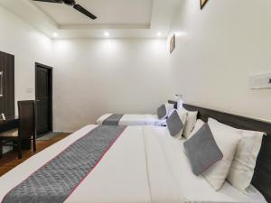 a bedroom with a large white bed with pillows at Super Hotel O Centrum in Gorakhpur