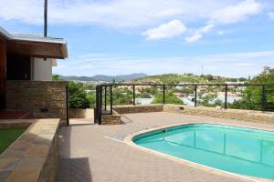 a swimming pool in front of a house at Cavallo Guesthouse in Windhoek