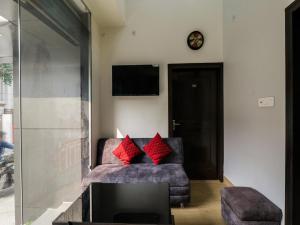 a living room with a couch with two red pillows at Super Hotel O Centrum in Gorakhpur