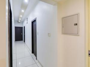 a hallway with white walls and a television on a wall at Super Hotel O Centrum in Gorakhpur