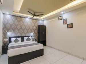 a bedroom with a bed and a ceiling fan at Super Hotel O Centrum in Gorakhpur +24 photos