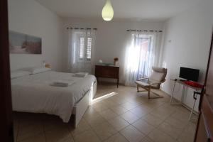 Un dormitorio con una cama y una silla y un televisor. en VicoloHOME, en Fragneto lʼAbate