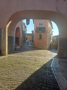 an archway in a building with a brick street at VicoloHOME in Fragneto lʼAbate