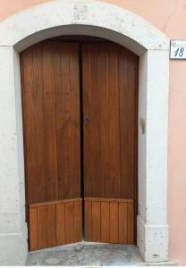 a wooden door in a building with an arch at VicoloHOME in Fragneto lʼAbate