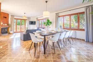 a dining room with a table and white chairs at Villa Ribera de Son Veri in El Arenal
