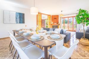 a dining room with a table and white chairs at Villa Ribera de Son Veri in El Arenal