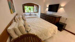 ein Schlafzimmer mit einem großen Bett und einem Fernseher in der Unterkunft Hotel Marina Quinta do Porto in Arraial d'Ajuda + 90 Fotos