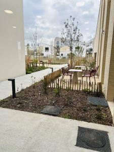 a garden with chairs and a table and a fence at Nouvelles Sylphides in Carrières-sous-Poissy
