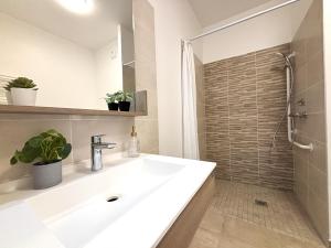 a bathroom with a sink and a shower at Nouvelles Sylphides in Carrières-sous-Poissy