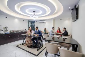a group of people sitting at a table in a restaurant at FabHotel Well Back in Mumbai