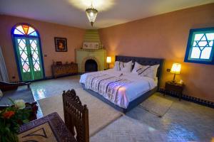 ein Schlafzimmer mit großem Bett und Kamin in der Unterkunft Bluegreen Guest House Marrakech in Aït Amara