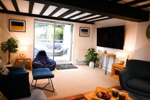 ein Wohnzimmer mit Sofa und Fernseher in der Unterkunft Gate Cottage, Saltwood Village in Sandling Junction