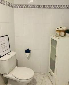 bagno bianco con servizi igienici e armadietto. di O remanso de arcade a Arcade Altre 6 foto