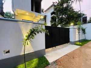 a house with a black and white fence at THE ONE Villa in Weligama
