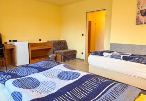 a room with two beds and a desk and a chair at 33 - 16 Hotelkamer voor twee personen in Bunkenburg