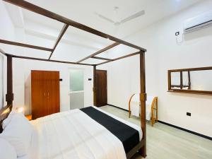 a bedroom with a canopy bed in a room at THE ONE Villa in Weligama