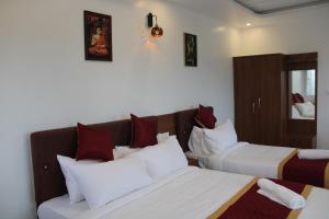 a hotel room with two beds and a couch at DJ Palace and Residency in Tiruvannāmalai