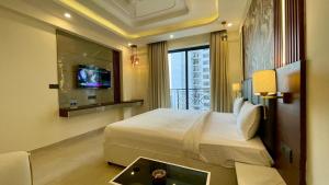 Una habitación de hotel con una cama y un televisor. en White Moon, en Lucknow