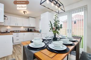 a kitchen with a table with plates and wine glasses at Spacious, 3BR, Coventry House | Sleeps 9 | Parking in Canley