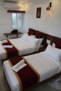 a hotel room with three beds and a table at DJ Palace and Residency in Tiruvannāmalai +31 photos
