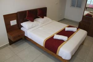 a bedroom with a large bed with two pillows at DJ Palace and Residency in Tiruvannāmalai