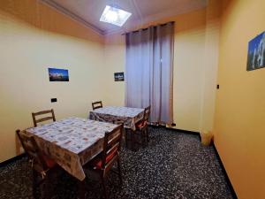 two tables and chairs in a room with a window at BB Sextum in Genoa