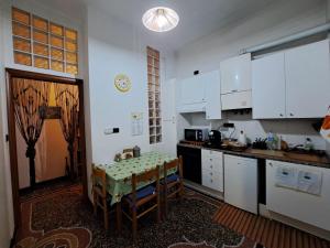 a kitchen with white cabinets and a table with a table cloth at BB Sextum in Genoa