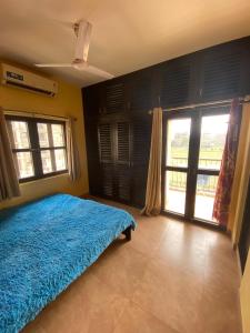 a bedroom with a blue bed with a blue blanket at Krishna Divine 2 Bedroom Home in mayapur