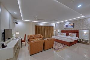 a hotel room with a bed and two chairs at The Fern Residency, Bodhgaya in Bodh Gaya