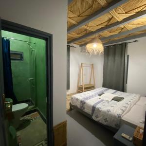 アイット・ベン・ハドゥにあるAuberge Etoile Filante d Or Ksar Ait Ben Haddouのベッドのある寝室とシャワー付きのバスルーム