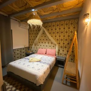 une chambre avec un lit et un lustre dans l'établissement Auberge Etoile Filante d Or Ait Ben Haddou, à Aït Ben Haddou