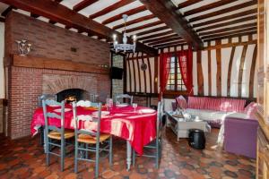 a dining room with a table and a fireplace at Gîte du Gros Hêtre in Sainte-Beuve-en-Rivière
