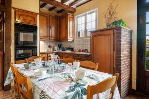 a kitchen with a table with chairs and a table cloth at Gîte du Gros Hêtre in Sainte-Beuve-en-Rivière