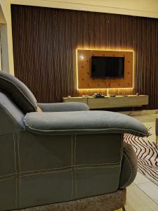 Una sala de estar con un sofá y un televisor. en AIN LUXE Stay, en Idogwari