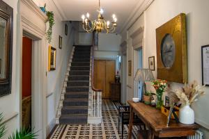 a hallway with a staircase with a table and a chandelier at Dorian House Boutique B&B - Free Parking! in Bath
