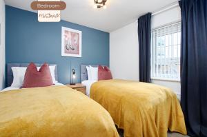 two beds in a room with blue walls at Spacious, 3BR, Coventry House | Sleeps 9 | Parking in Canley