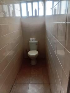 un piccolo bagno con servizi igienici e finestra di ThandyTasha luxury apartments a Lusaka